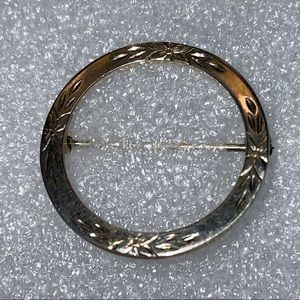 A round gold etched scarf pin